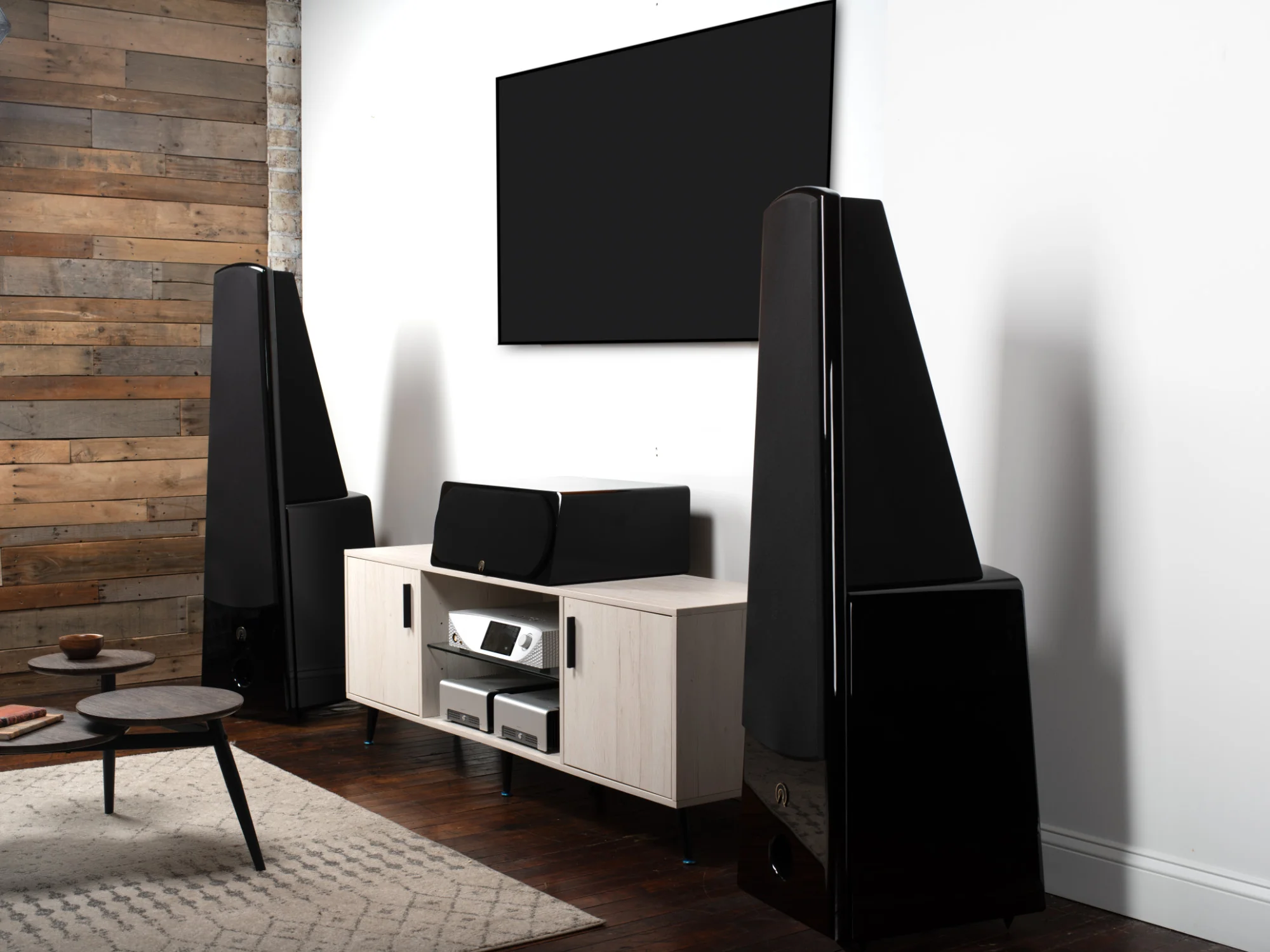 Alta Audio floorstanders flanking a media console in a wood-panelled living room