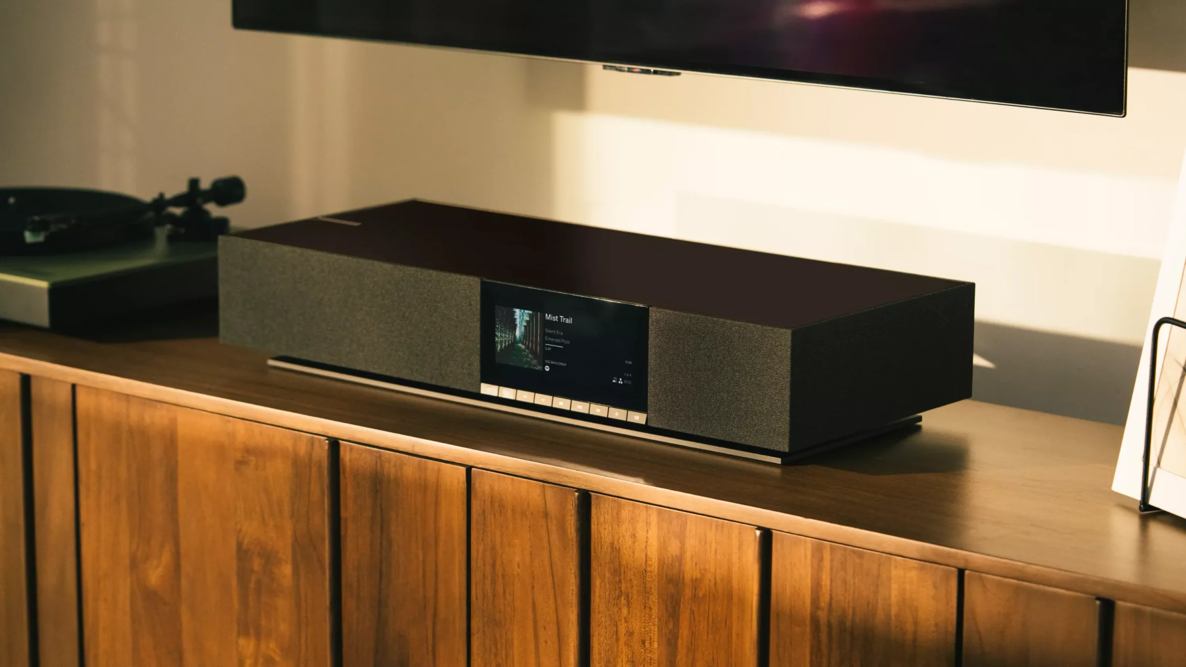 A Cambridge Audio Evo streaming system glowing on a walnut console