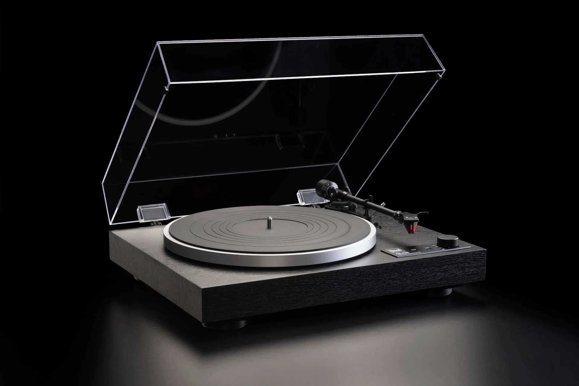 Dual turntable with a clear dust cover on a dark background