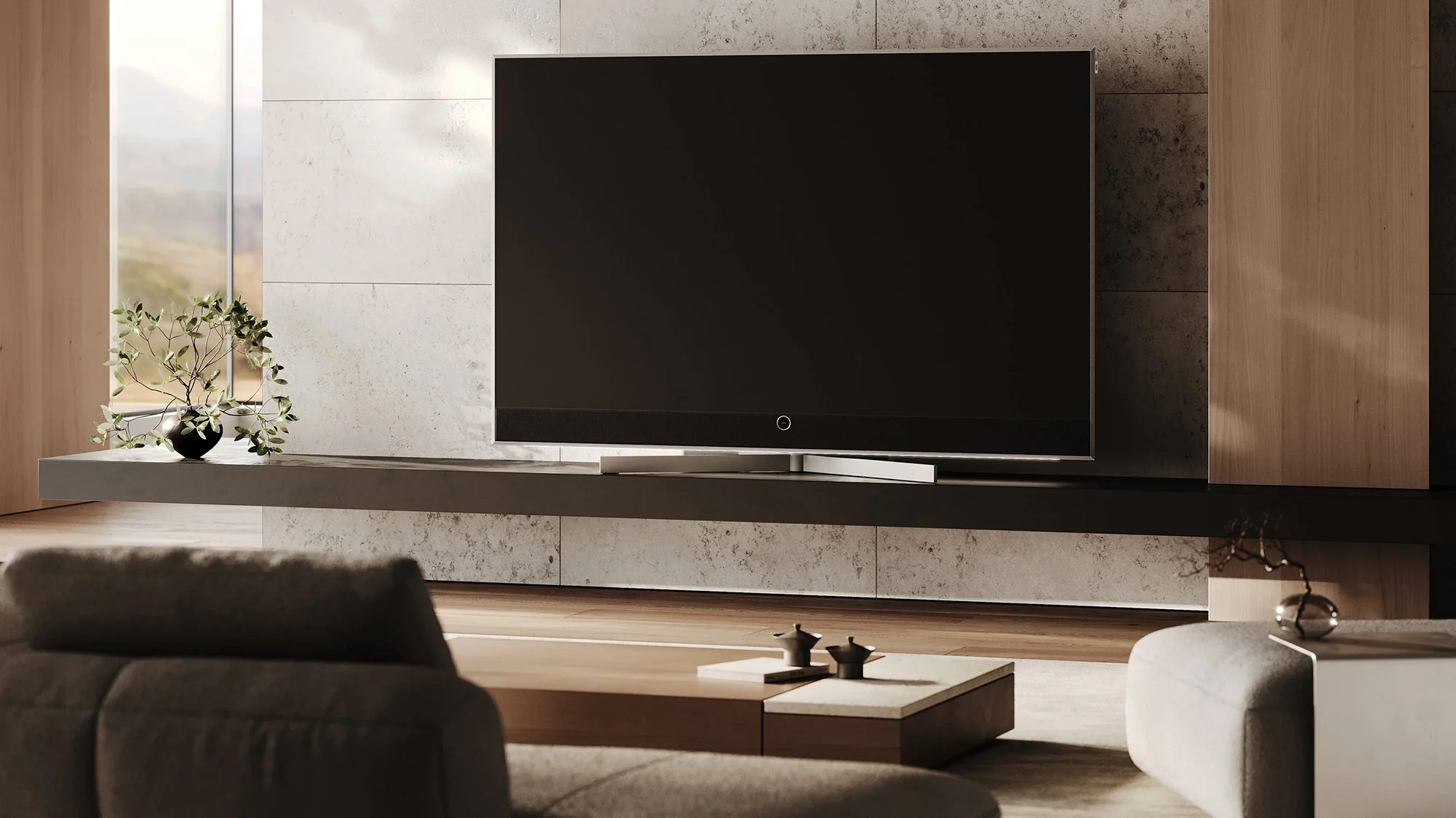 A Loewe television mounted above a low media bench in a bright living room
