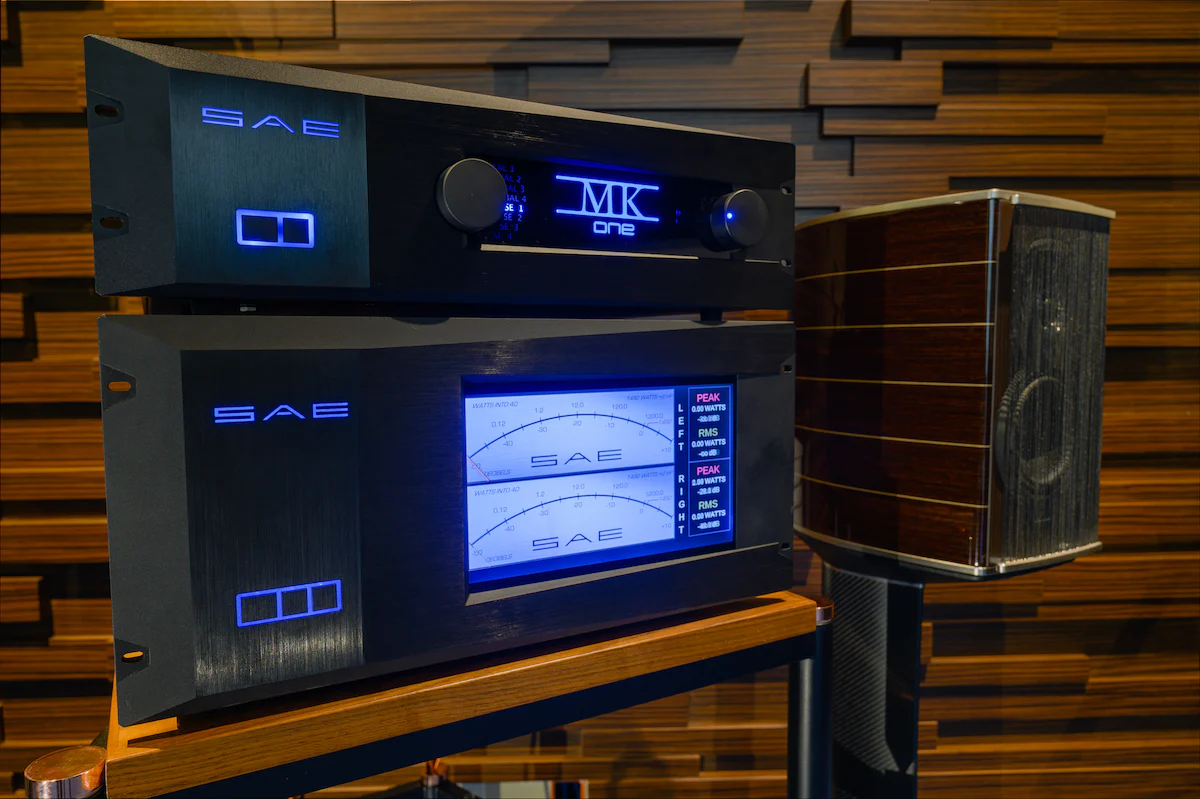 SAE amplifiers stacked with wide blue power meters against slatted wood
