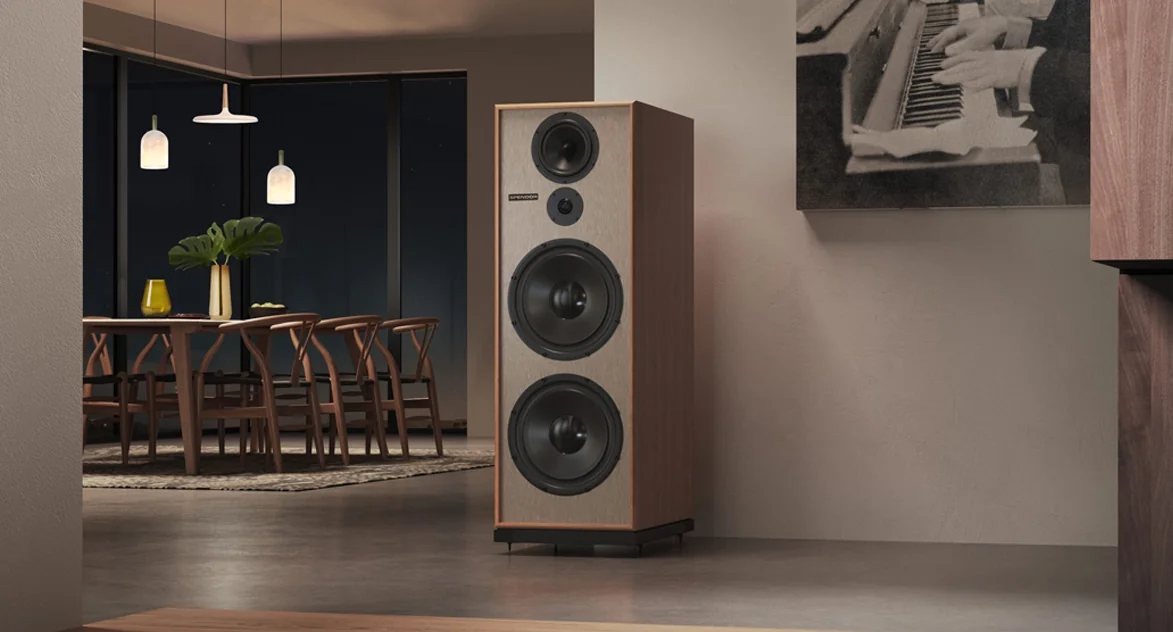A Spendor Classic loudspeaker in light wood at the edge of a dining room