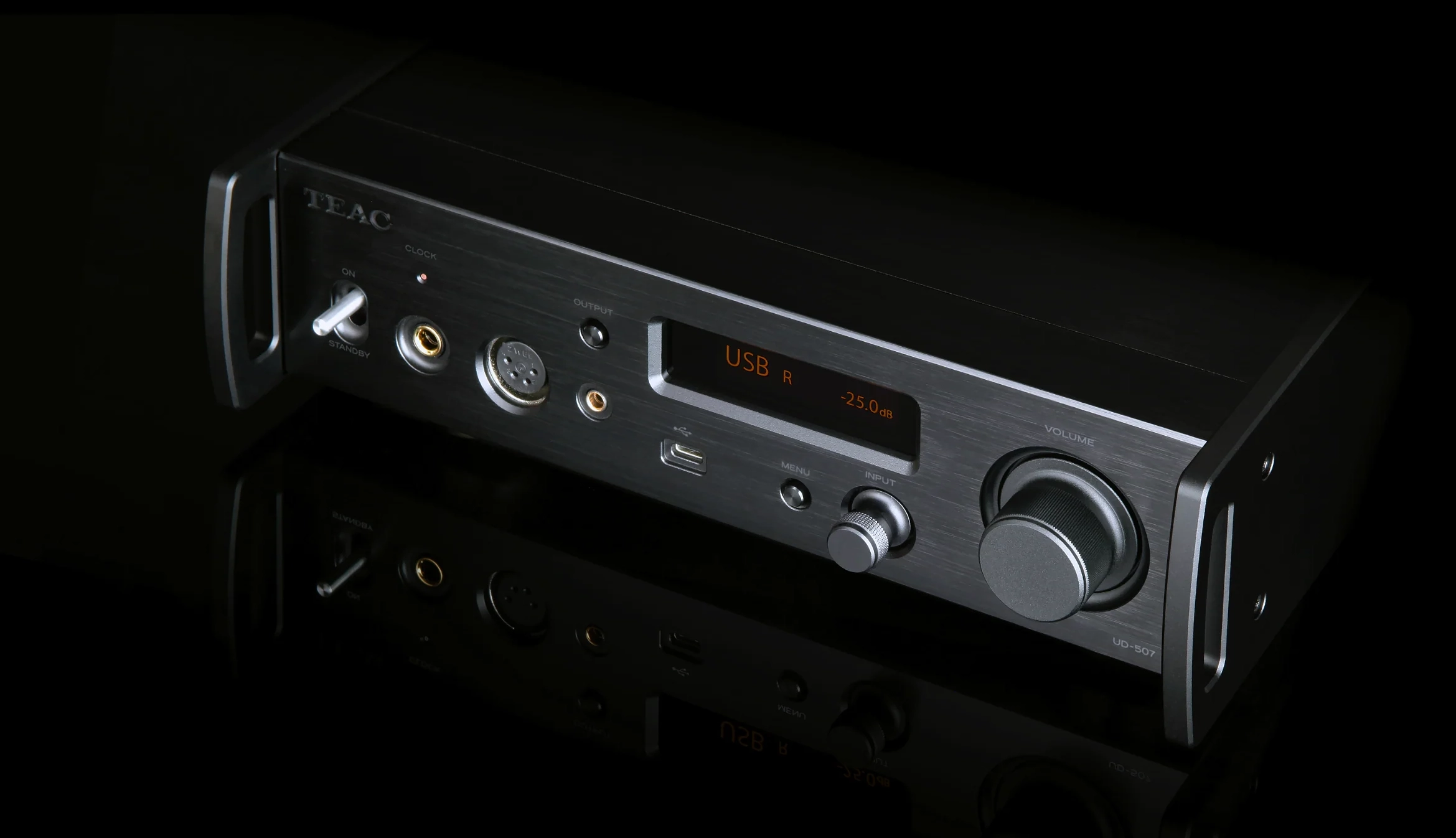 A TEAC player silver fascia emerging from darkness, amber display lit