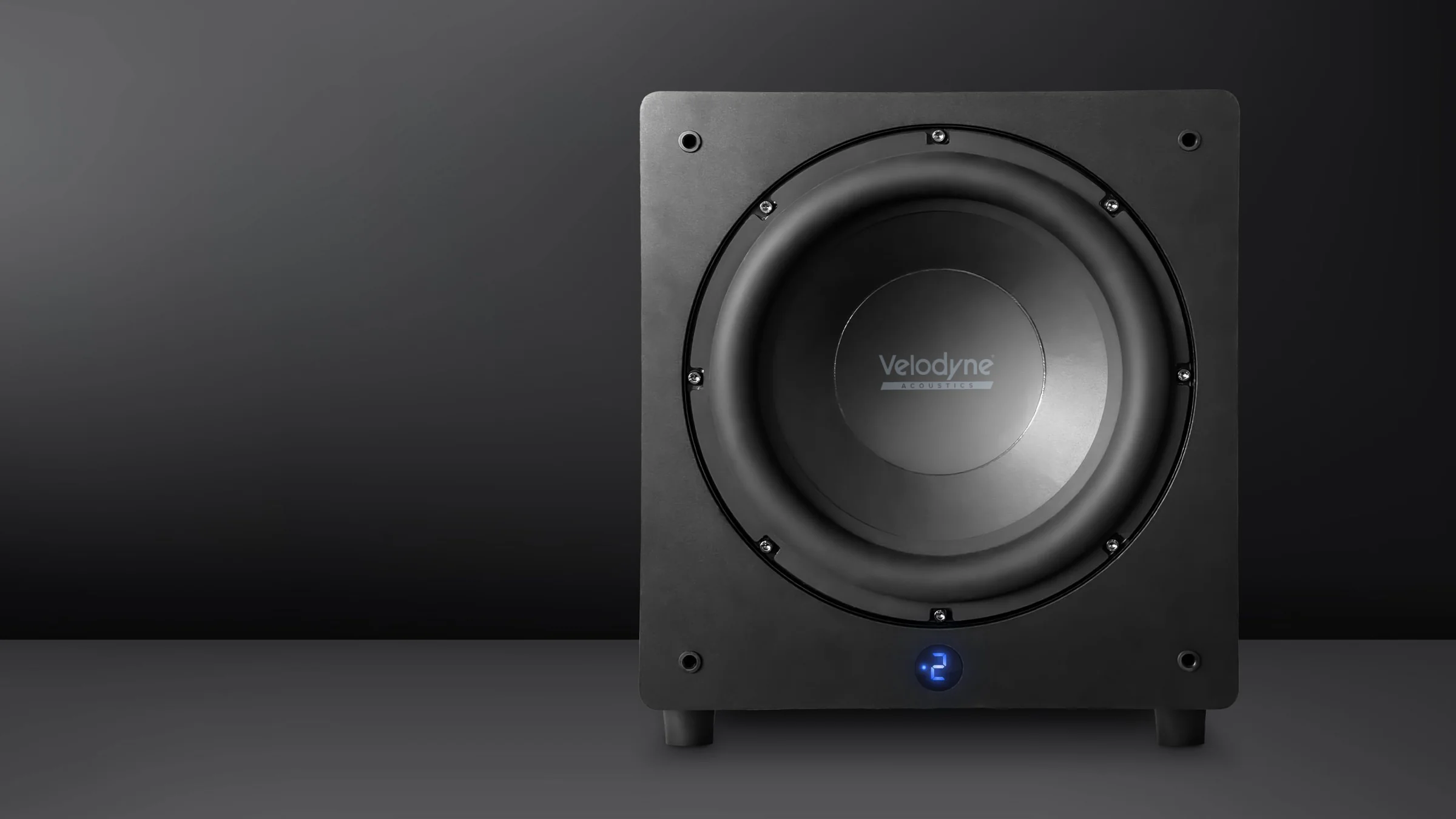 A Velodyne subwoofer in black, driver bare, on a graphite ground
